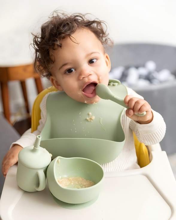 Safe food-grade silicone baby feeding set for self-feeding, featuring a bib, spoon, bowl, and sippy cup in mint green.